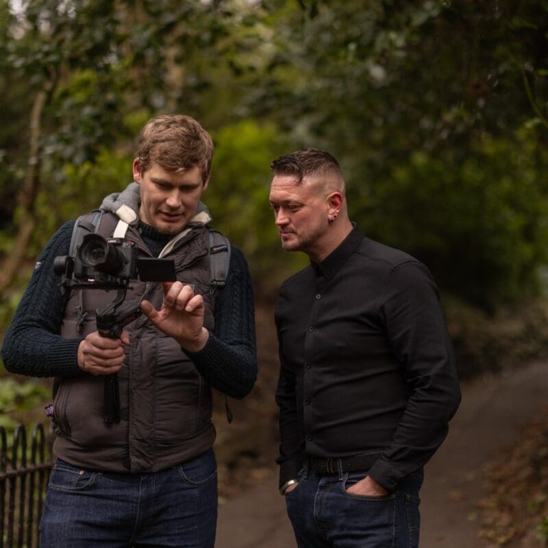 Two people reviewing camera footage outdoors on location