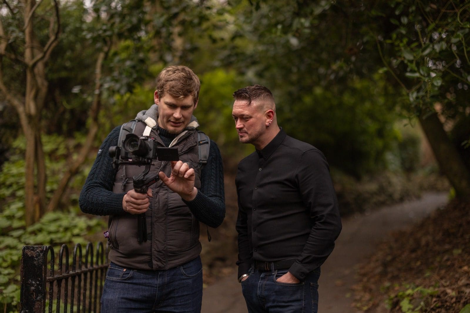 Two people reviewing camera footage outdoors on location