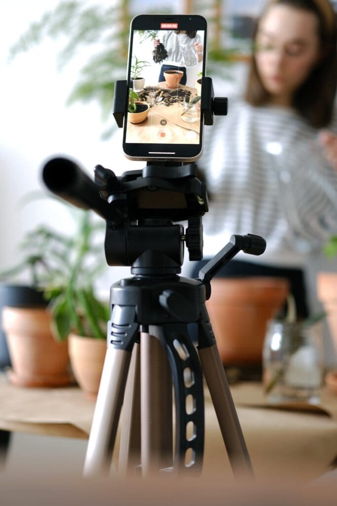 Smartphone mounted on a tripod filming a video at home