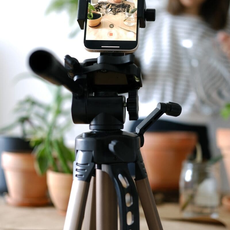 Smartphone mounted on a tripod filming a video at home